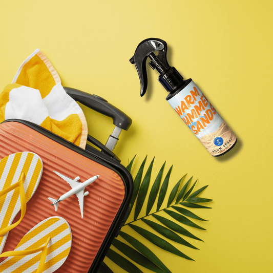 Warm Summer Sands Tropical Room Spray on yellow background with summer travel accessories