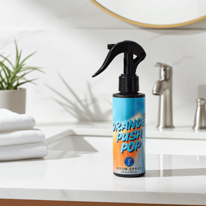 Room spray bottle labeled 'Orange Push Pop' on a bathroom counter.