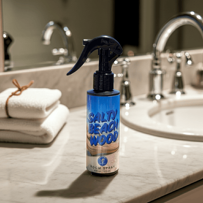 Room spray bottle labeled 'Salty Beach Wood' on a bathroom counter.